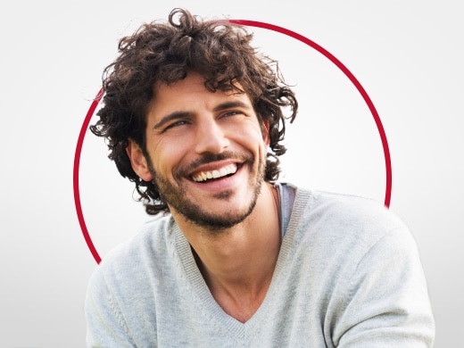 Usmievavý mladý muž v sivom svetri je šťastný po liečbe kvasinkovej infekcie prípravkom Canesten